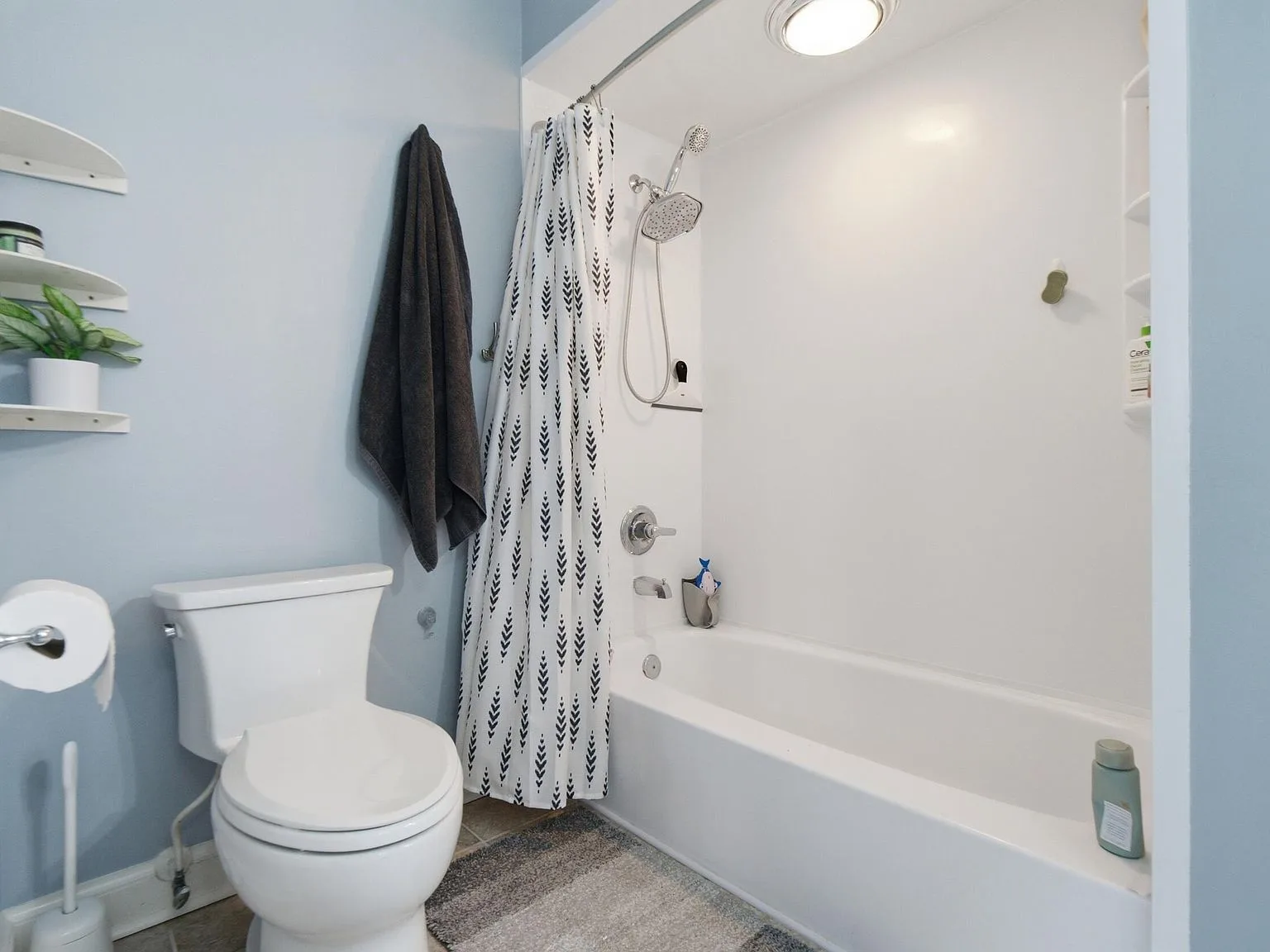 Bathroom shower and tub combo with chrome fixtures