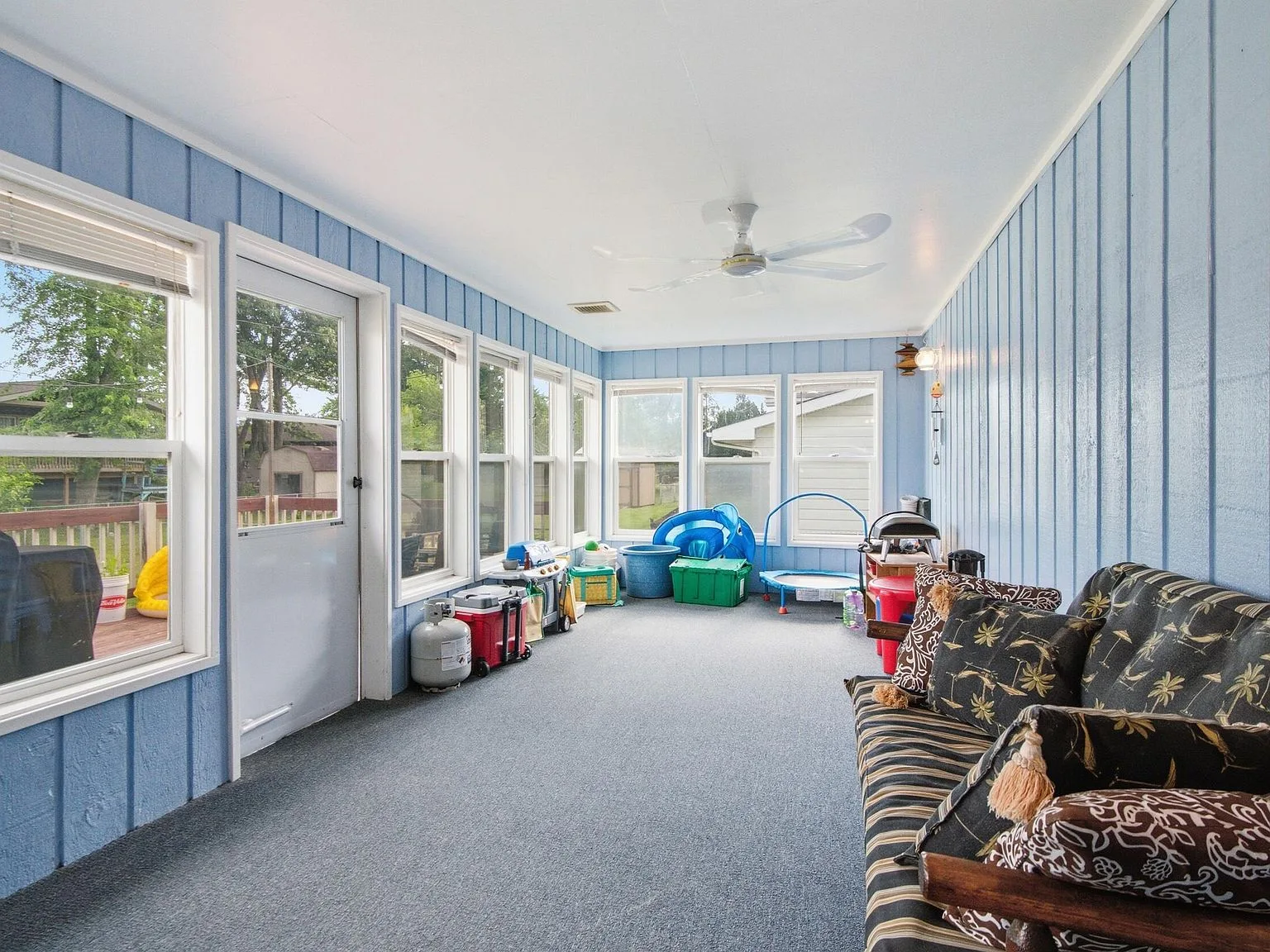 Three-season sunroom with blue paneled walls and large windows