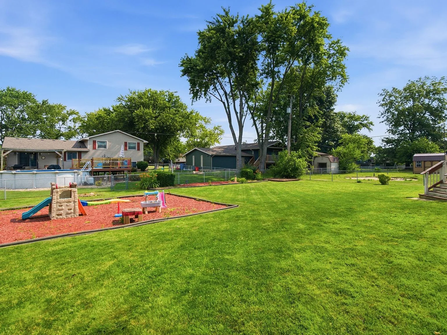 Spacious fenced backyard with large grass lawn