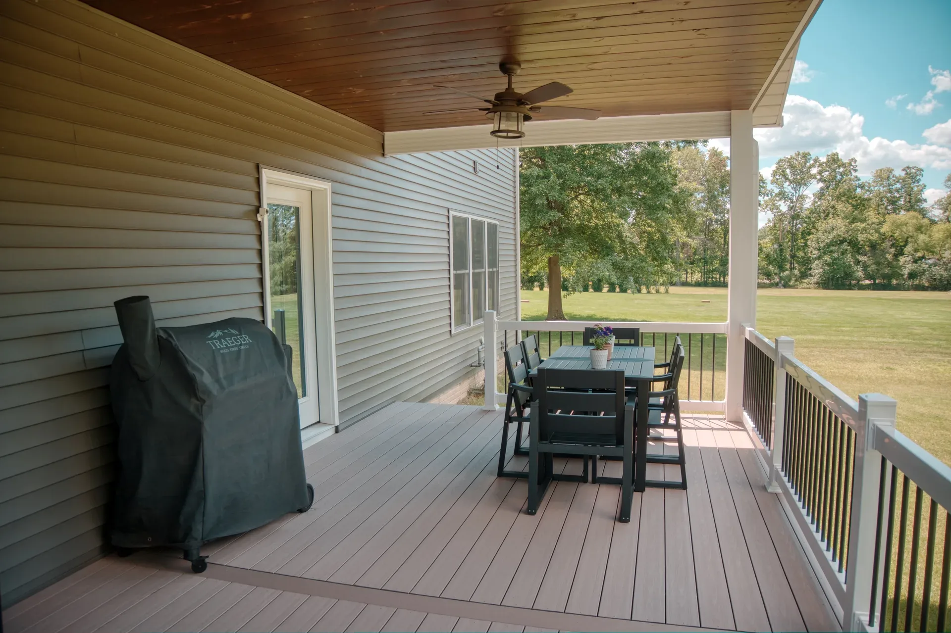 Covered rear deck with dining set overlooking the backyard