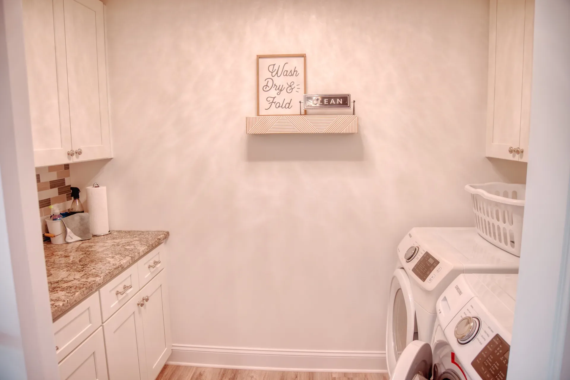 Second-floor laundry room with cabinetry and granite counters