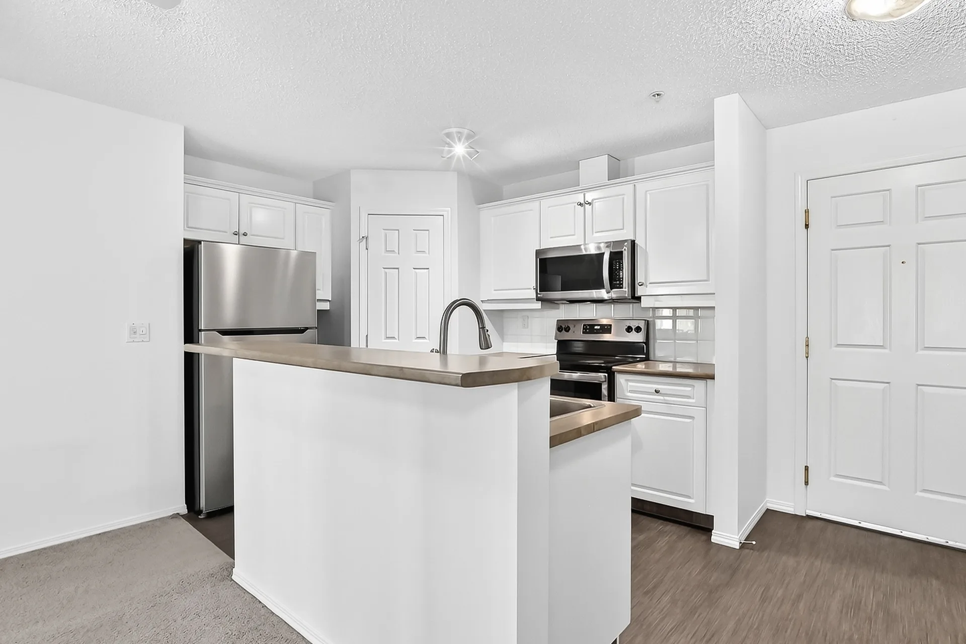 Galley kitchen with breakfast bar and stainless steel appliances