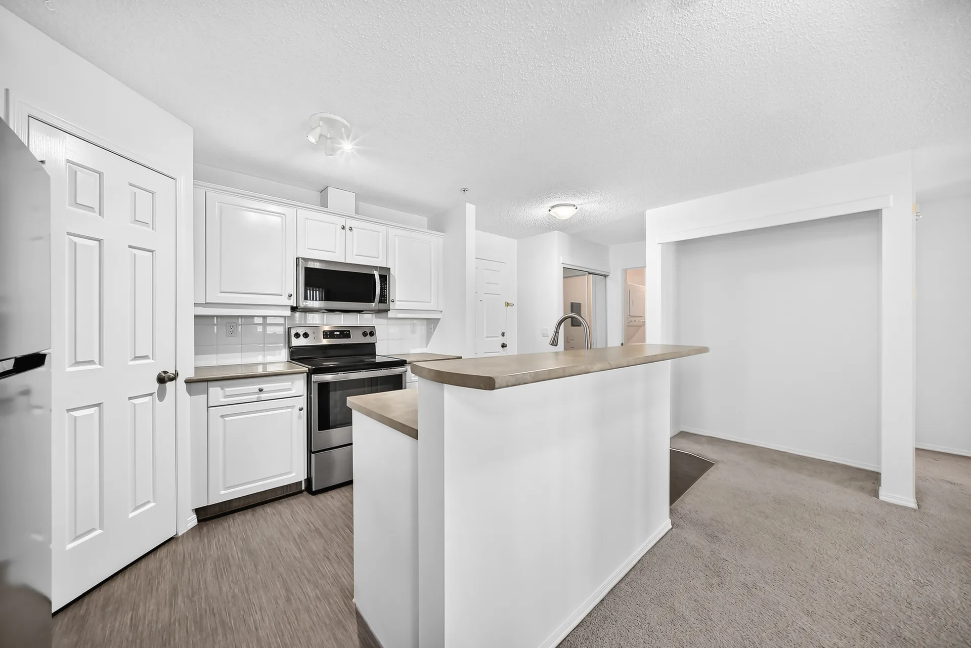 Wide-angle kitchen view with breakfast bar