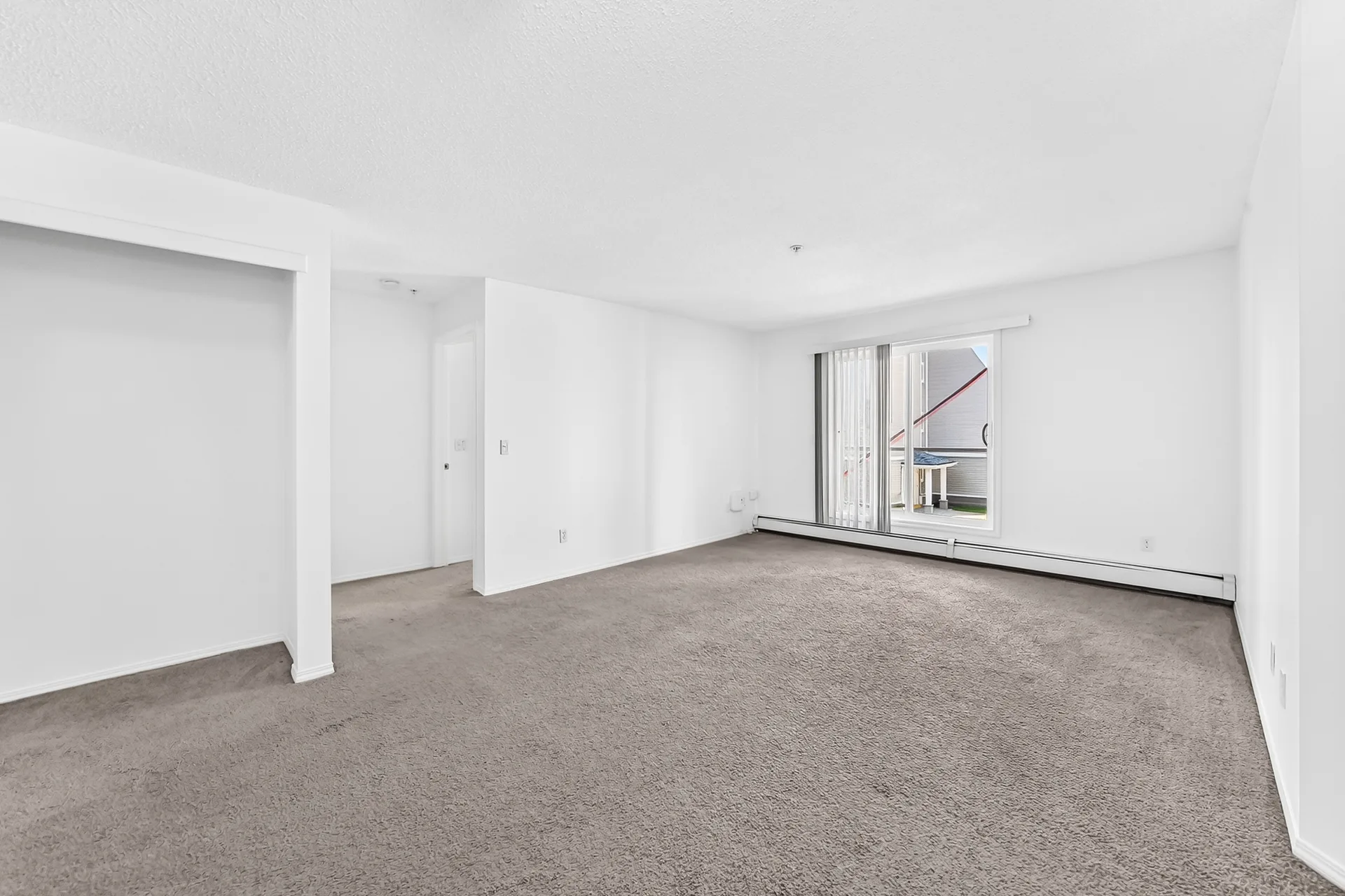 Bright west-facing living room with natural light and balcony access