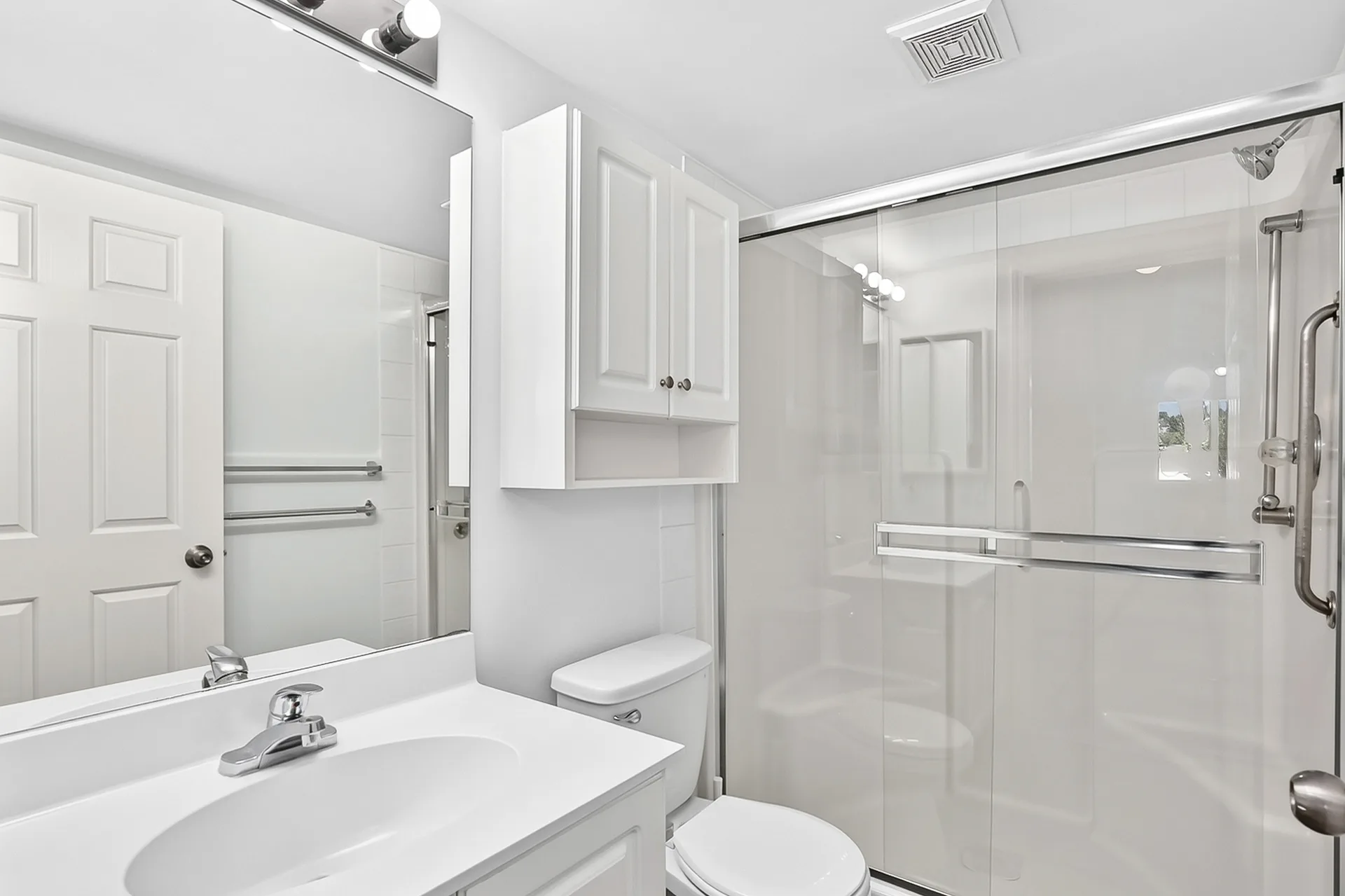 Modern bathroom with white vanity and glass shower enclosure
