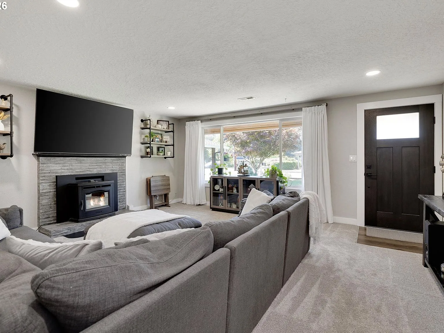 Living room with pellet stove, large picture windows, and natural light