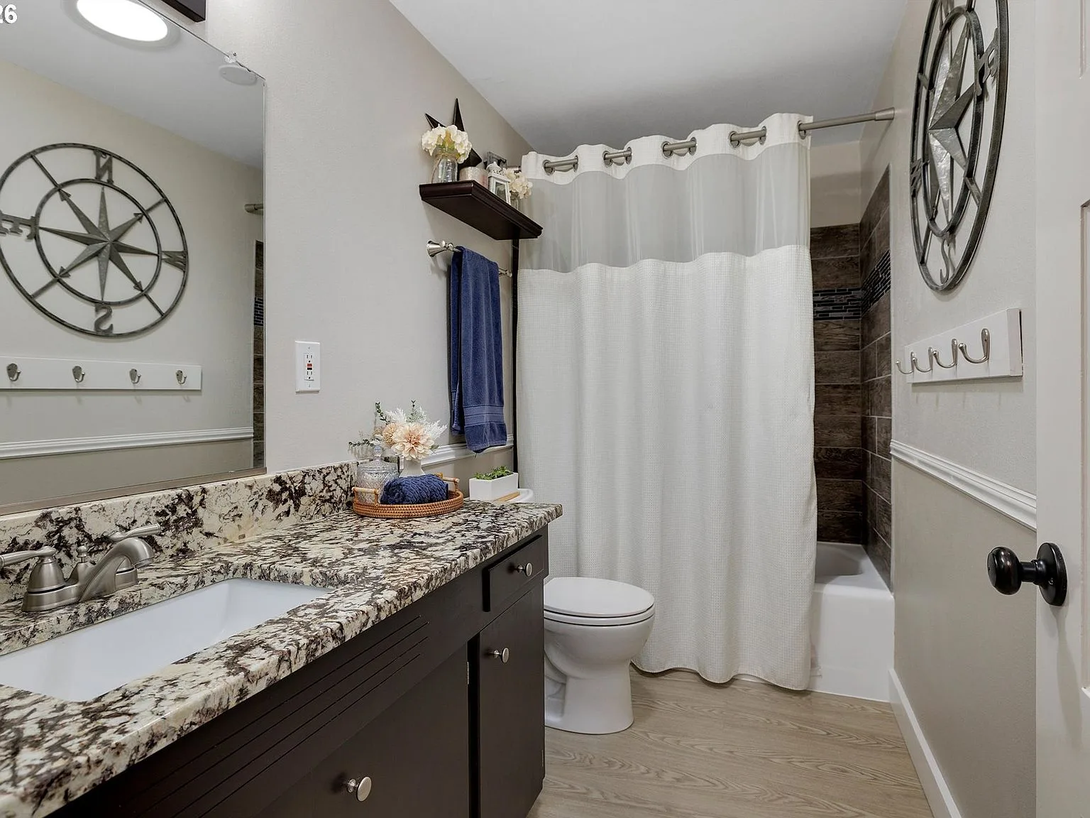 Updated bathroom with granite countertop and dark vanity