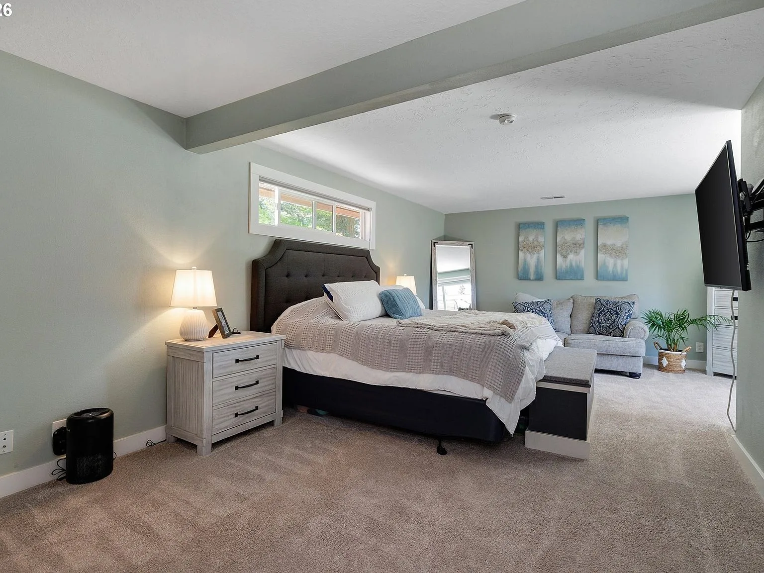 Primary bedroom with sage green walls and carpeted floors