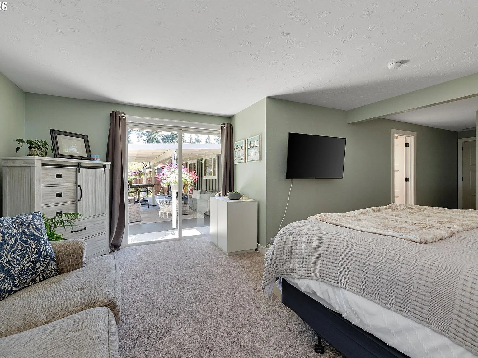 Primary bedroom with sliding glass door to covered patio