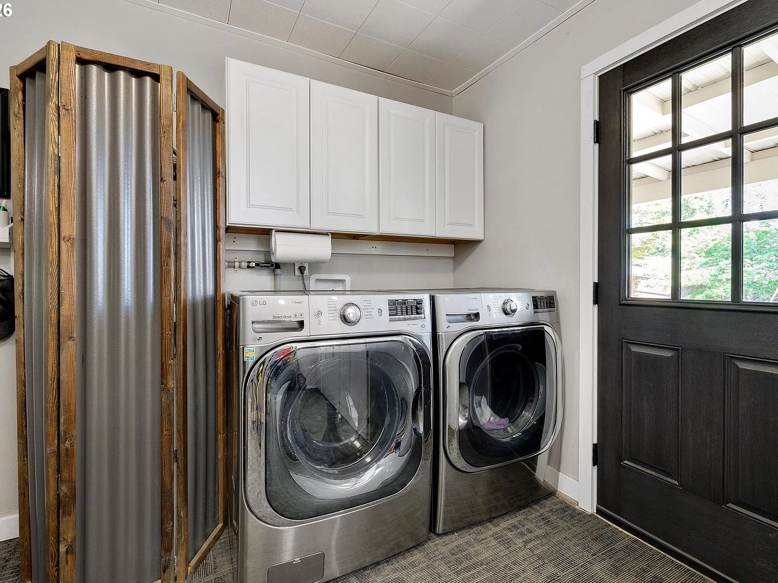 Laundry room with Maytag appliances and wall-mounted cabinets