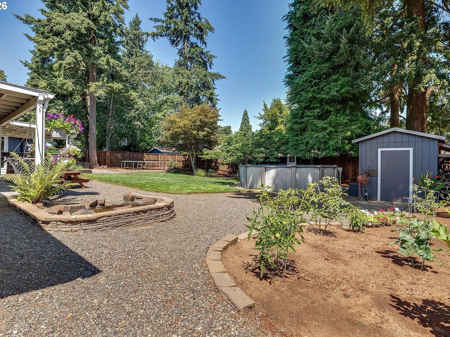 Backyard with covered patio, above-ground pool, water feature, and storage shed