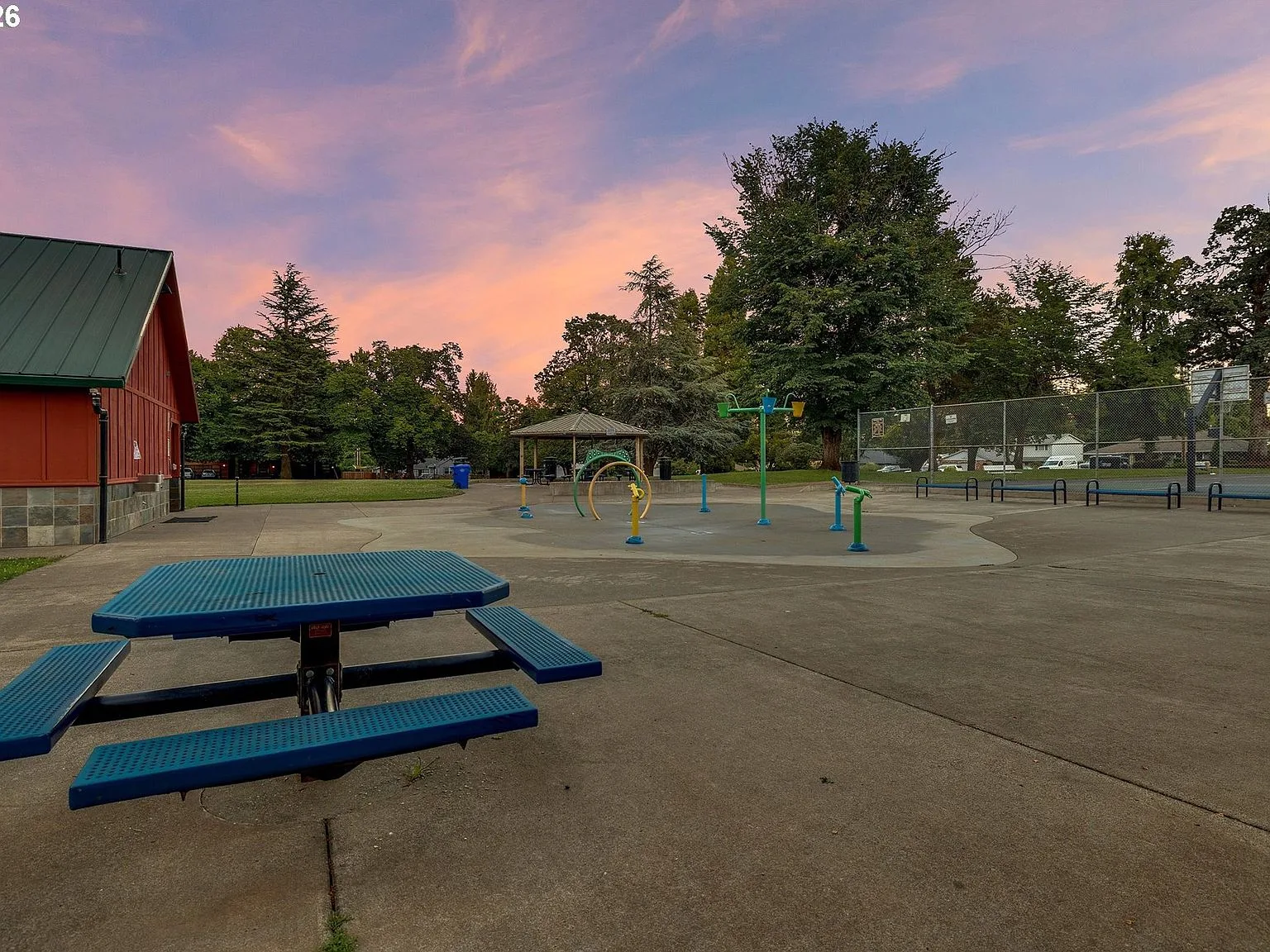 Rivercrest Park with splash pad, basketball court, and sunset sky three doors away