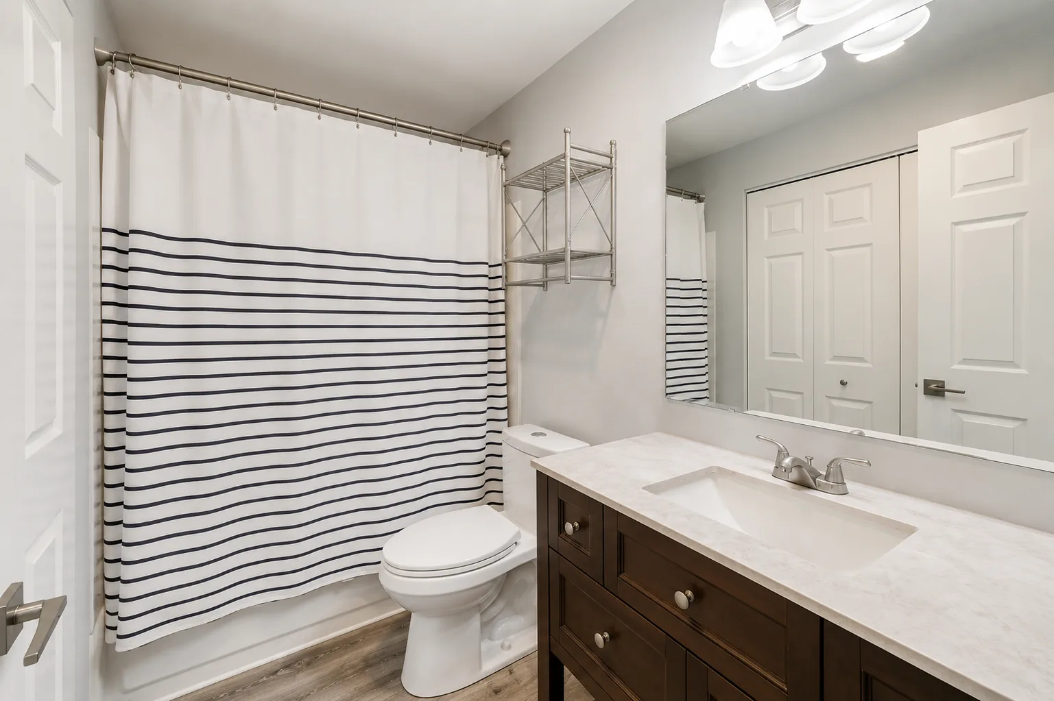Second bathroom with dark wood vanity and large mirror