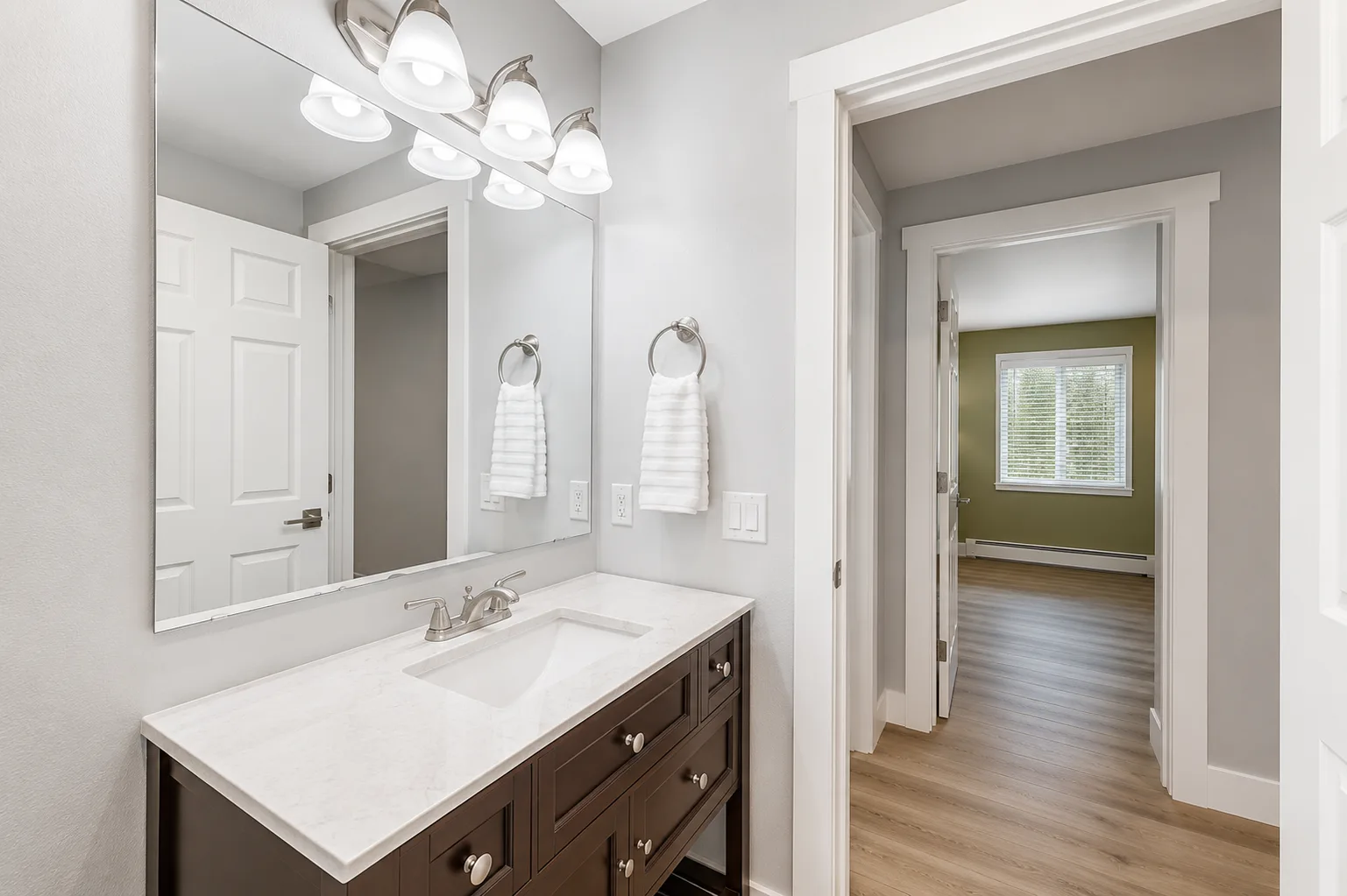 Bathroom vanity with multi-light sconce and frameless mirror