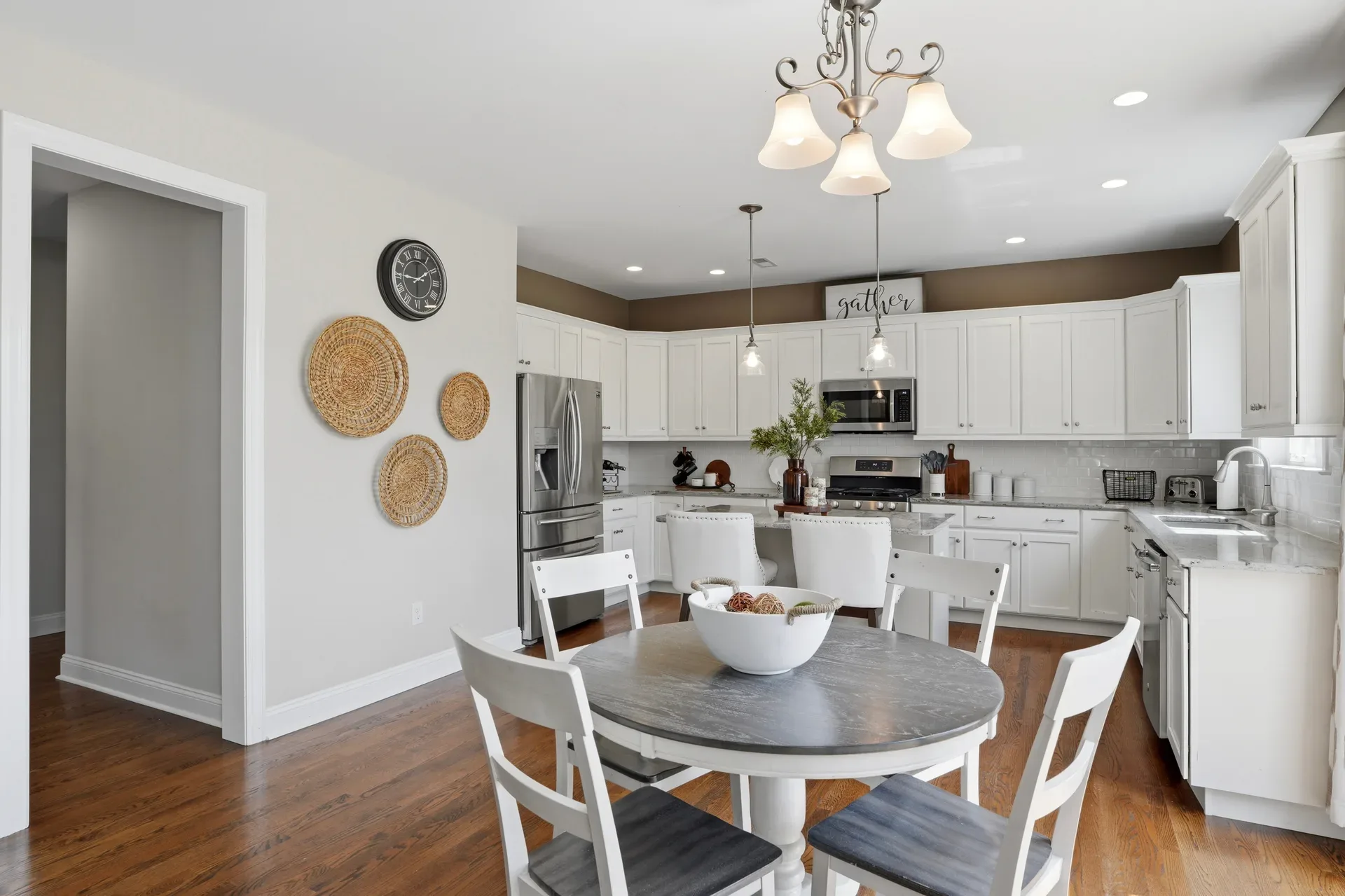 Kitchen and dining area with white cabinetry, granite countertops, and hardwood floors