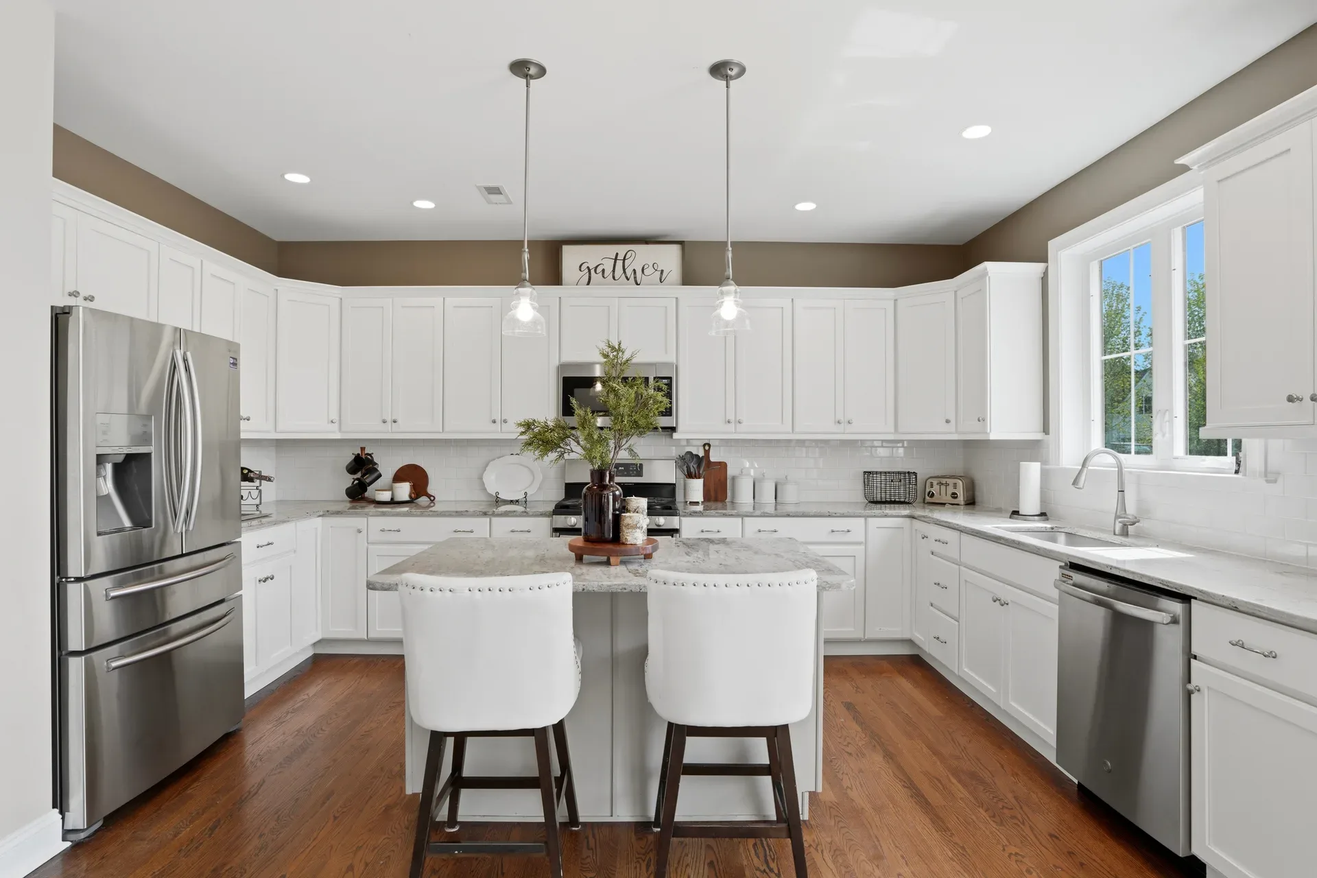 Modern kitchen island with white cabinets, quartz countertops, and subway tile backsplash