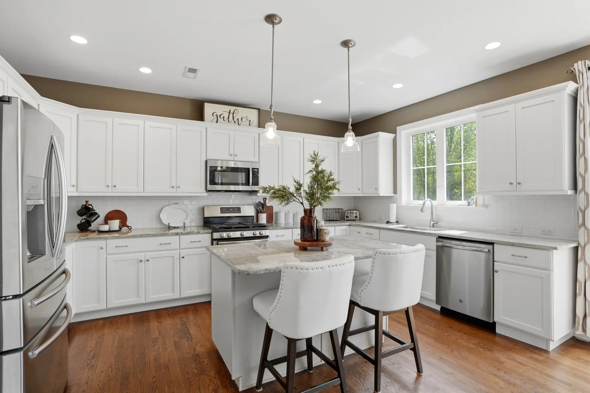 White kitchen with shaker cabinets, granite countertops, and stainless steel appliances