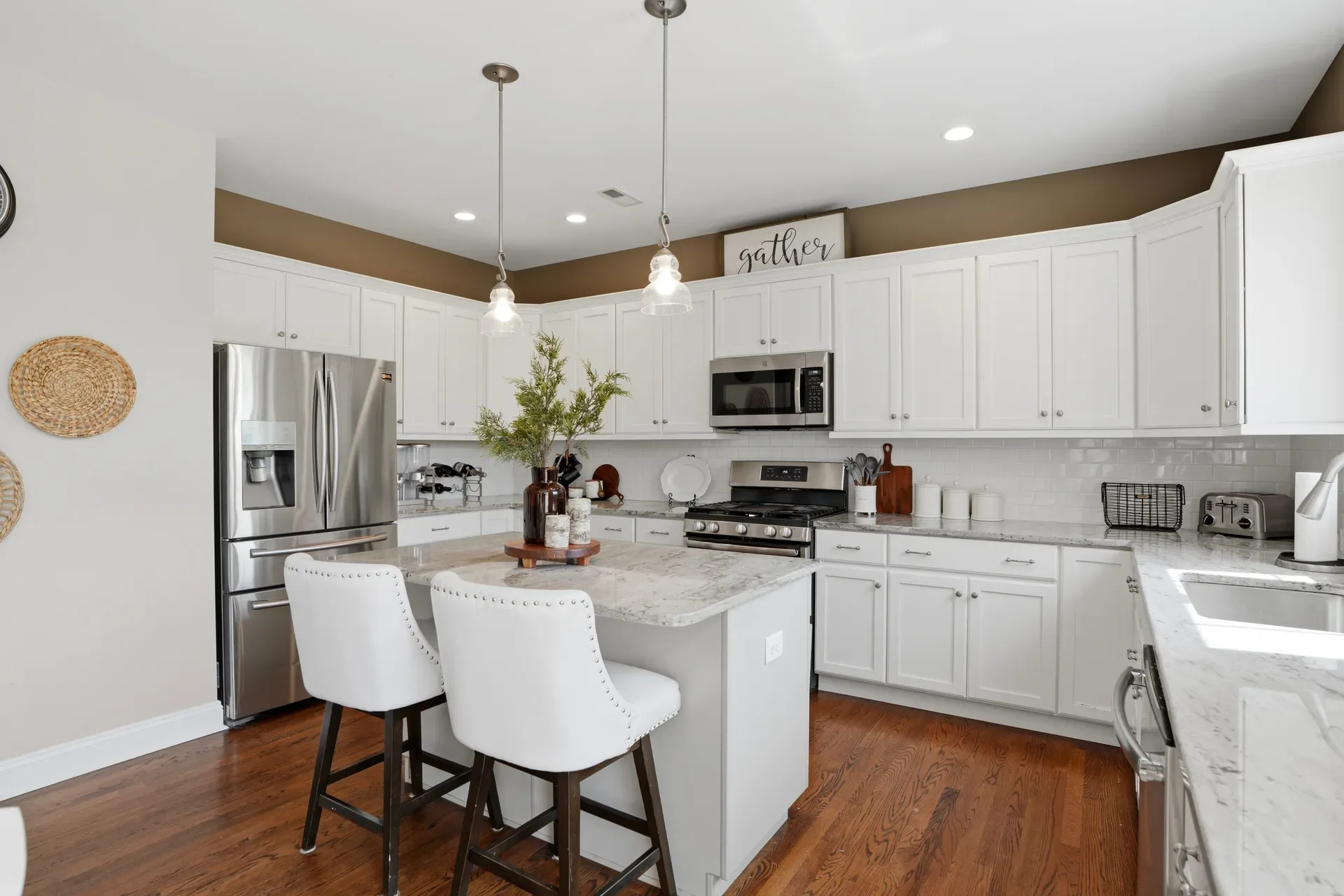 Kitchen interior with white cabinetry, grey granite countertops, and dark hardwood floors