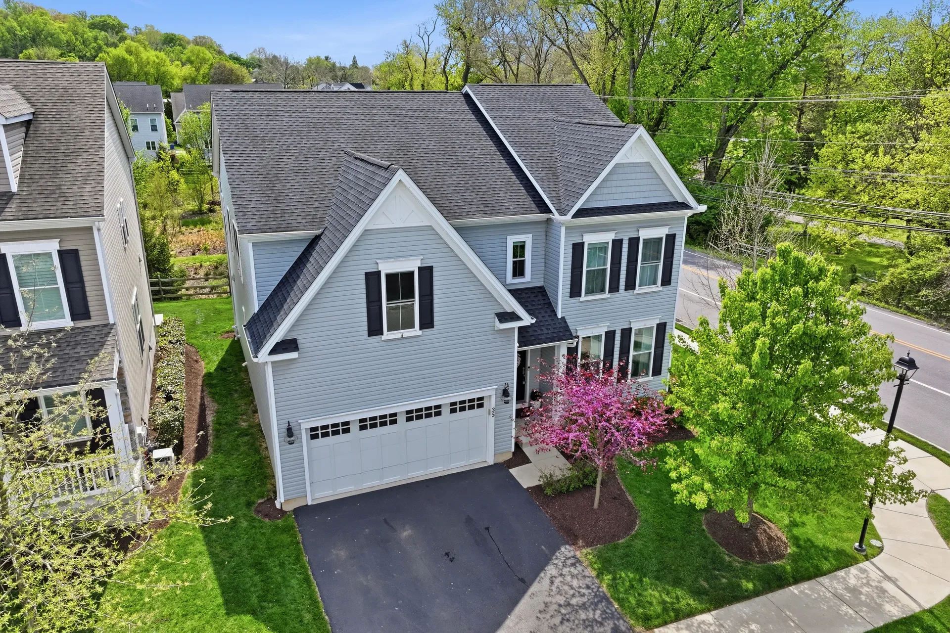 Aerial drone view of 35 Dickinson Lane, a two-story colonial home with blue siding and dark roofing in Plymouth Meeting, PA