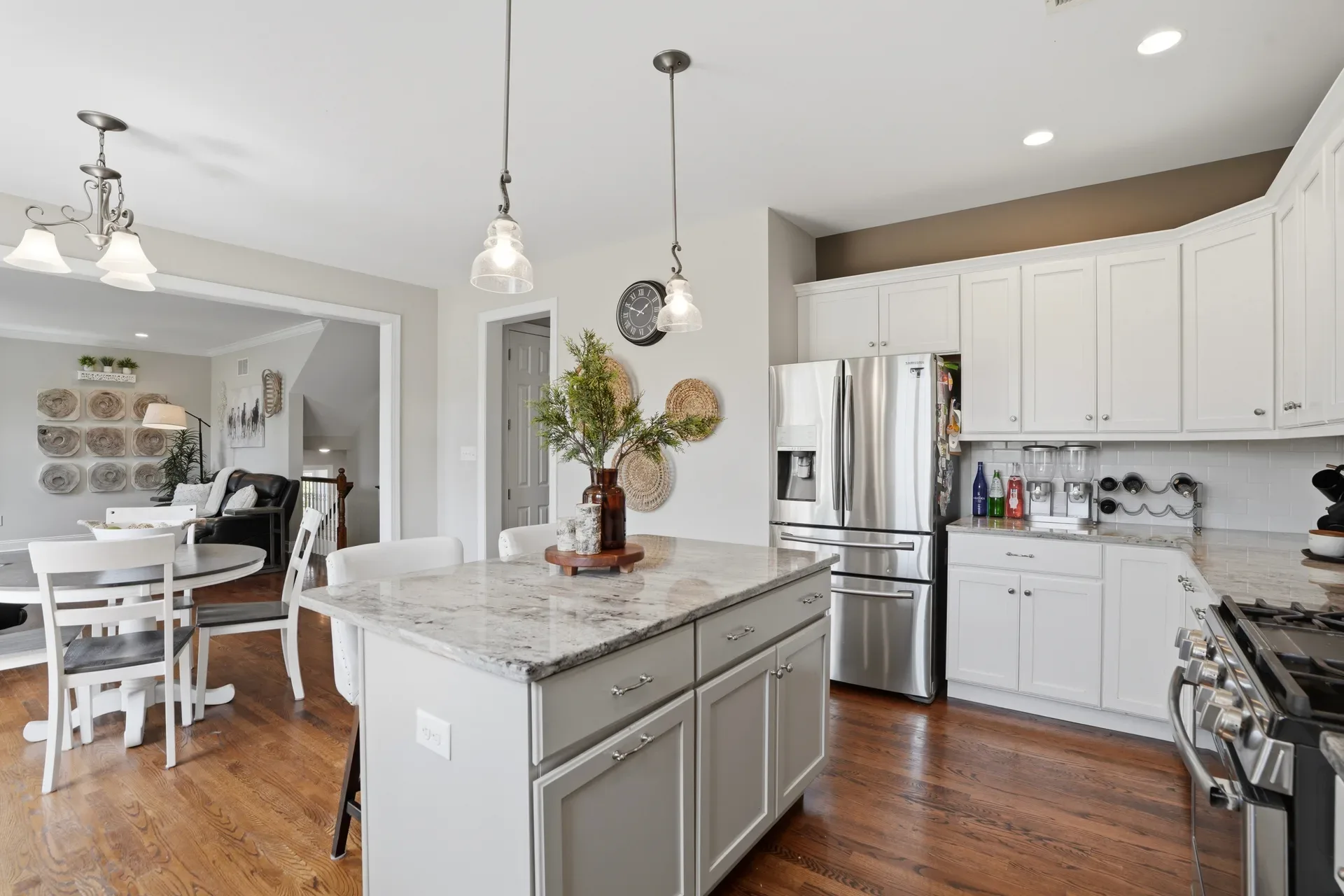 Wide-angle kitchen and dining area with grey island and granite countertops