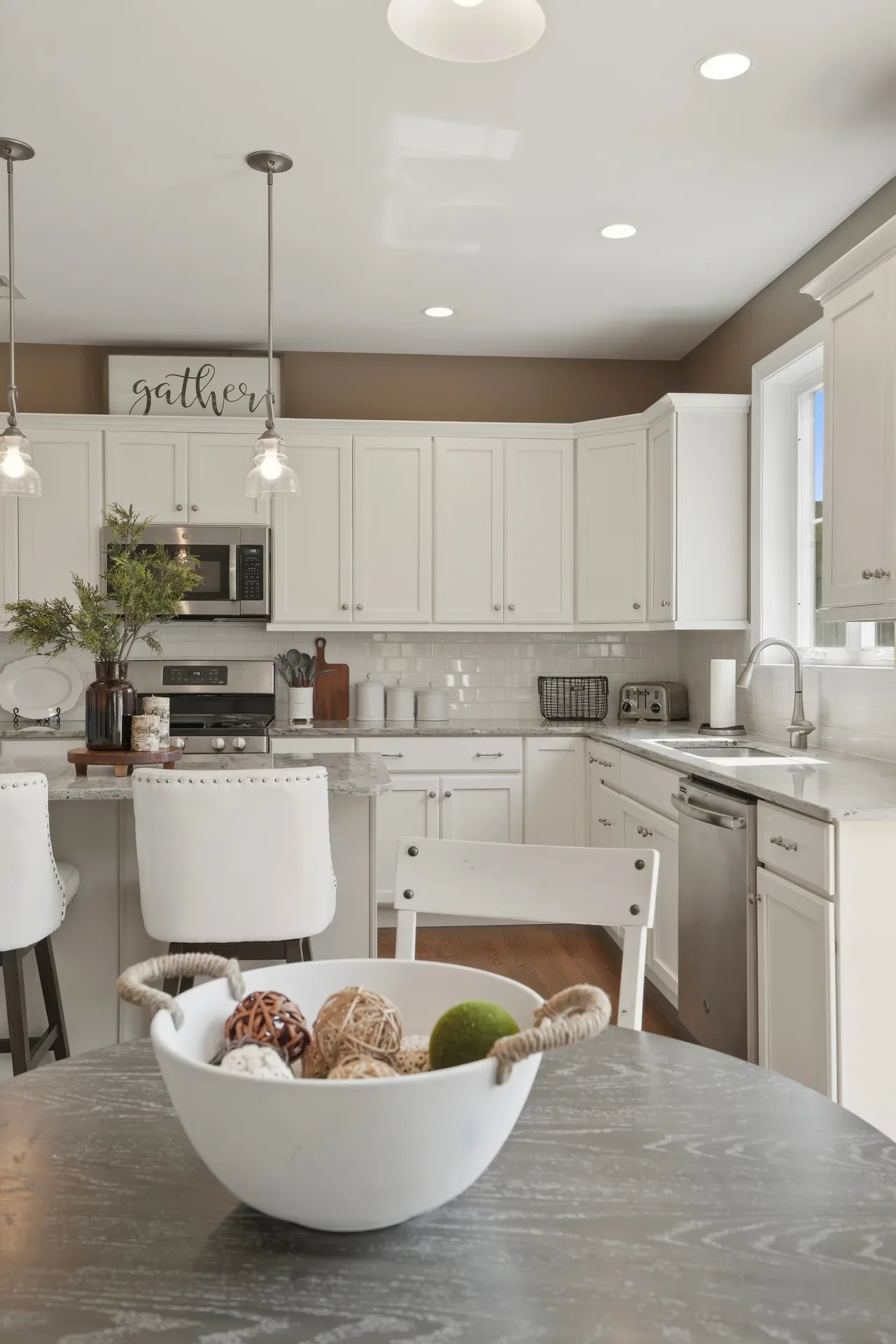 Kitchen interior with white shaker cabinets and light granite countertops