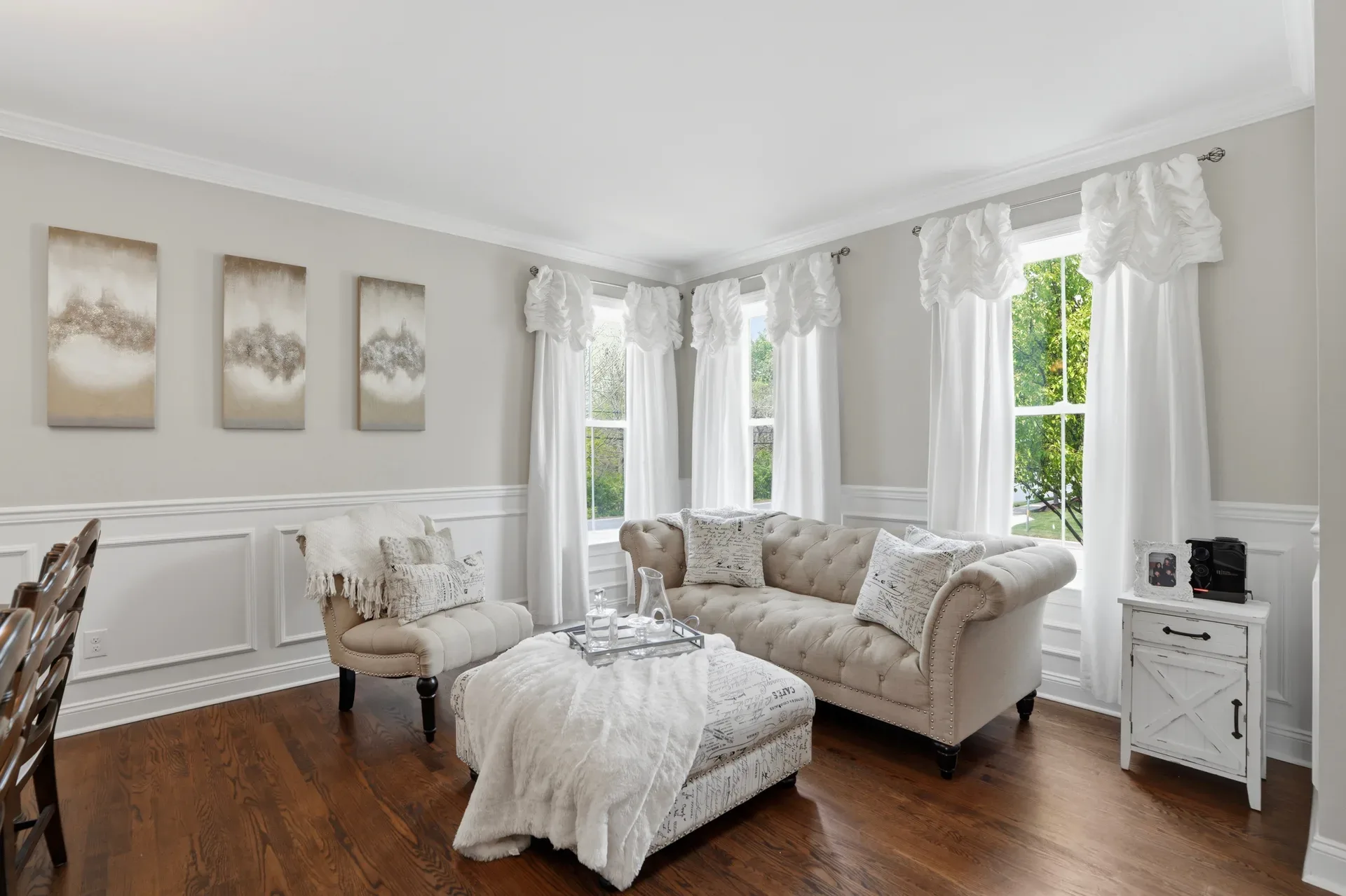 Living room with wainscoting, hardwood floors, and natural daylight