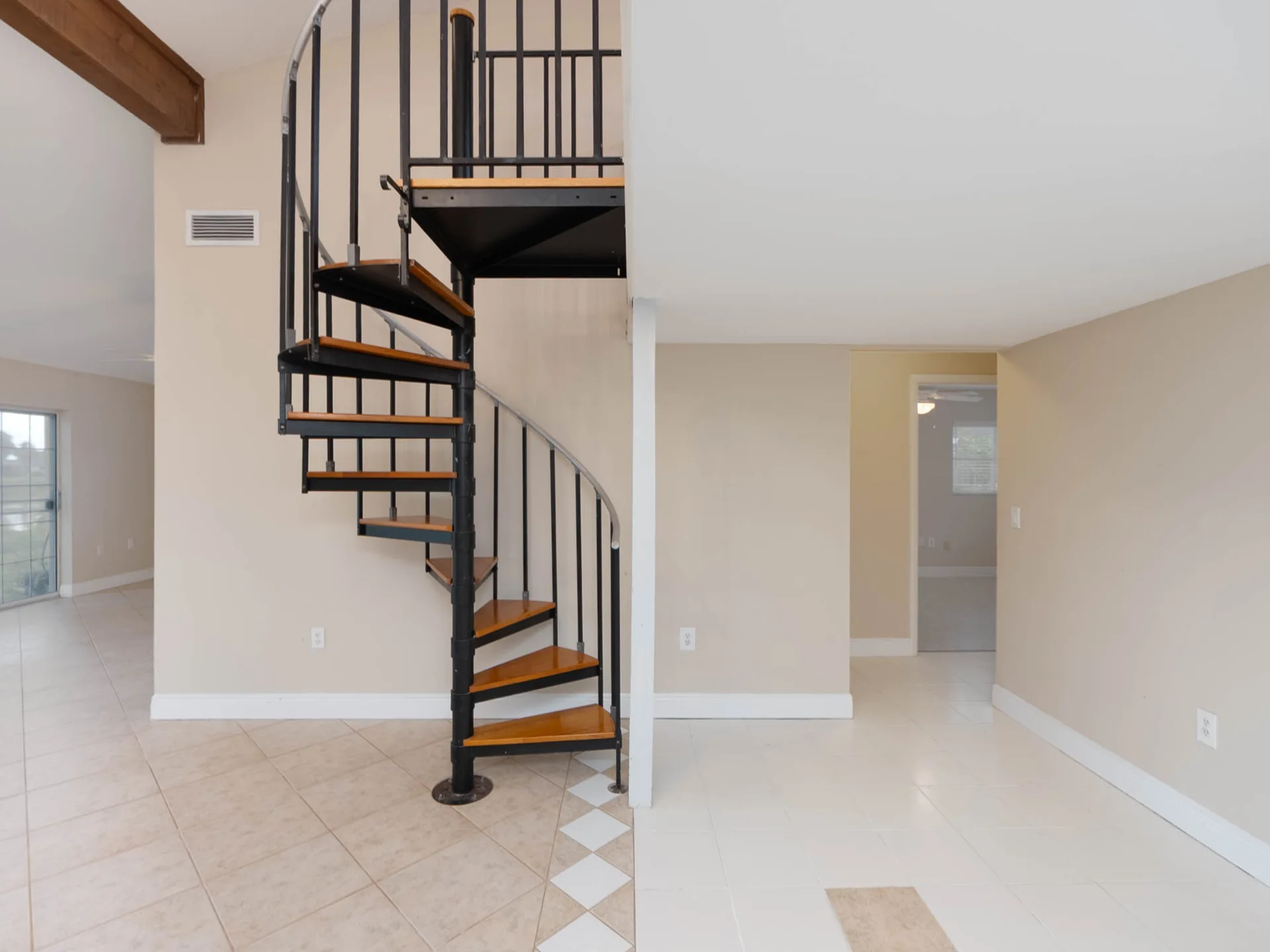 Spiral staircase foyer entrance at 1141 Sleepy Hollow Court in Venice, Florida, showing the unique loft access and ceramic tile flooring