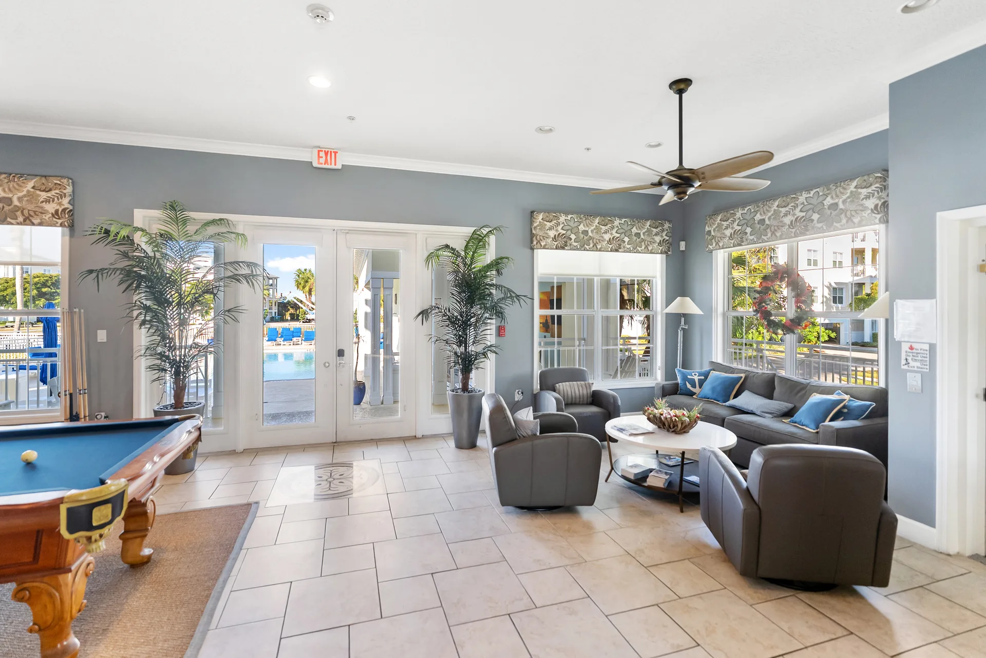 Bright recreation and living room in Palma Sola Bay Club condo with comfortable seating, neutral decor, and abundant natural light