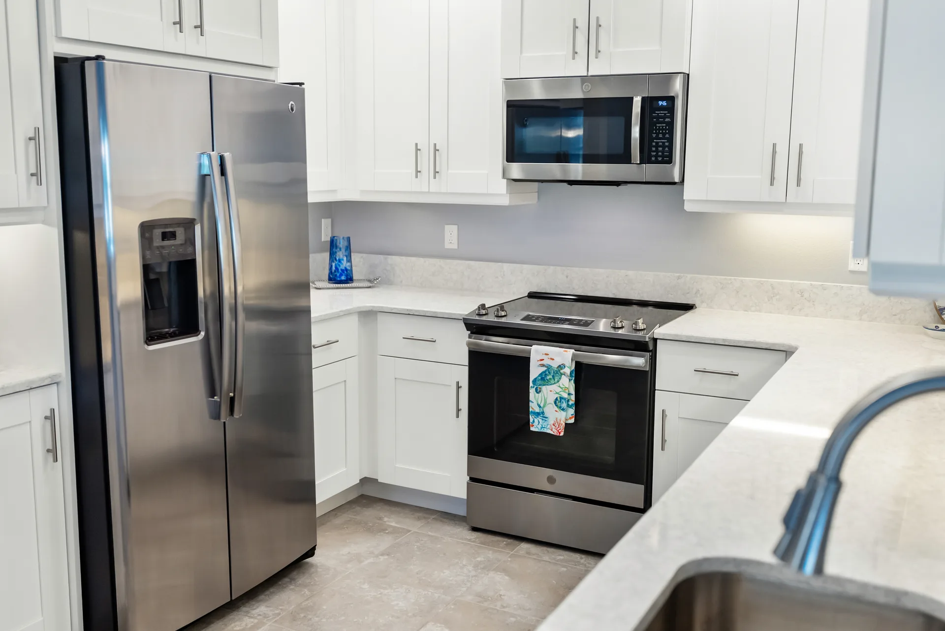 Modern kitchen with stainless steel appliances, solid surface countertops, and contemporary cabinetry in a Bradenton condo