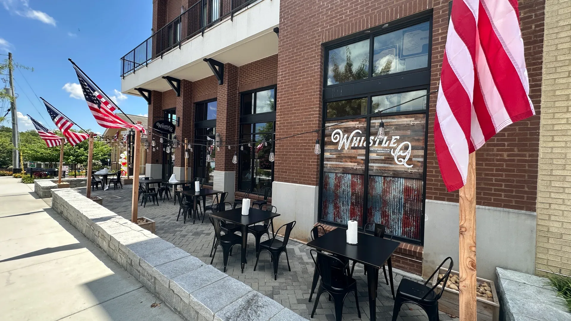 Whistle Q restaurant exterior patio and facade on Main Street in Flowery Branch Georgia