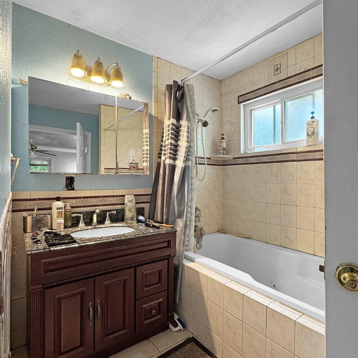 Bathroom with dark wood vanity, soaking tub, and tiled surround