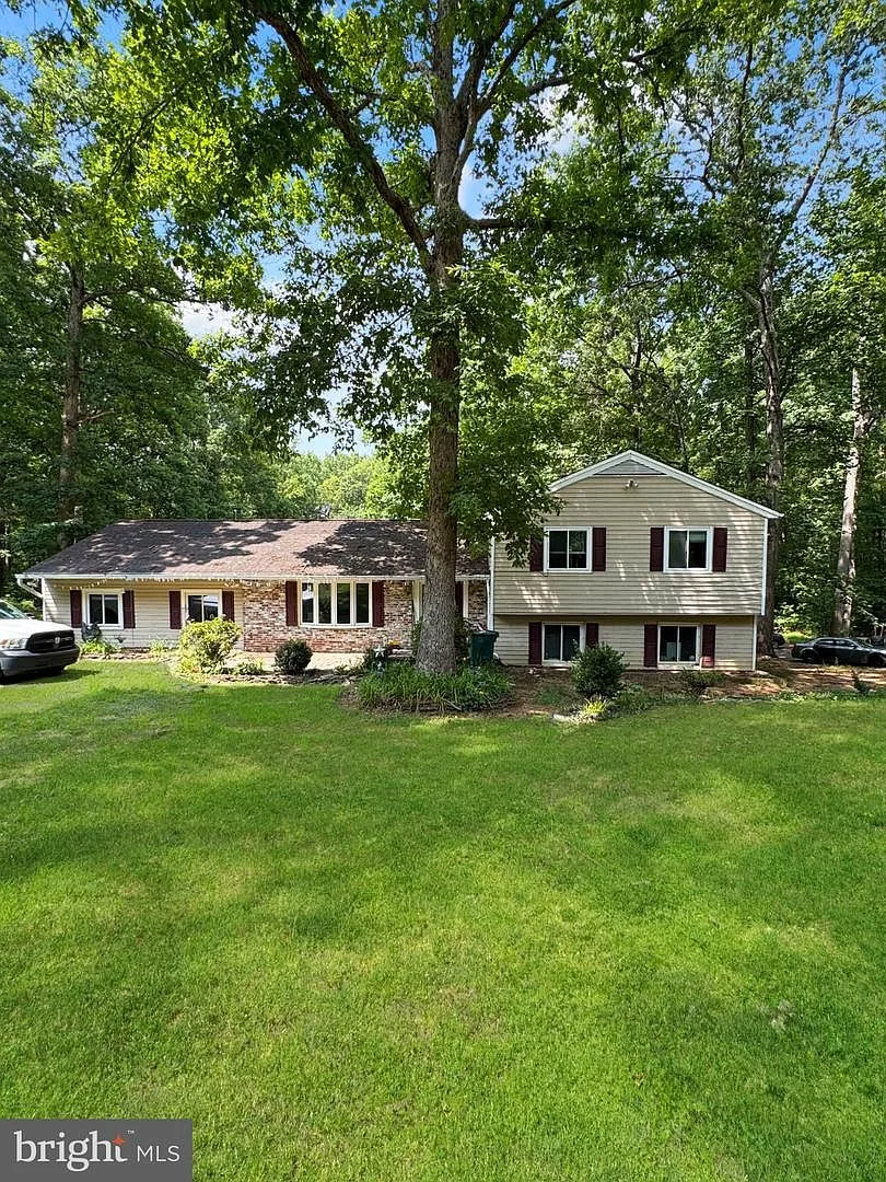 Front exterior of 4490 Silver Hill Ct showing split-level home with tan siding and brick accents