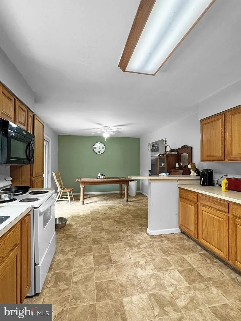 Kitchen and dining area with oak cabinetry and natural light