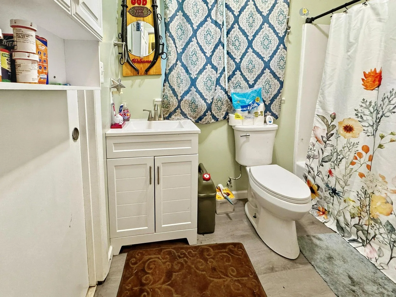 Full bathroom with white vanity and light green walls