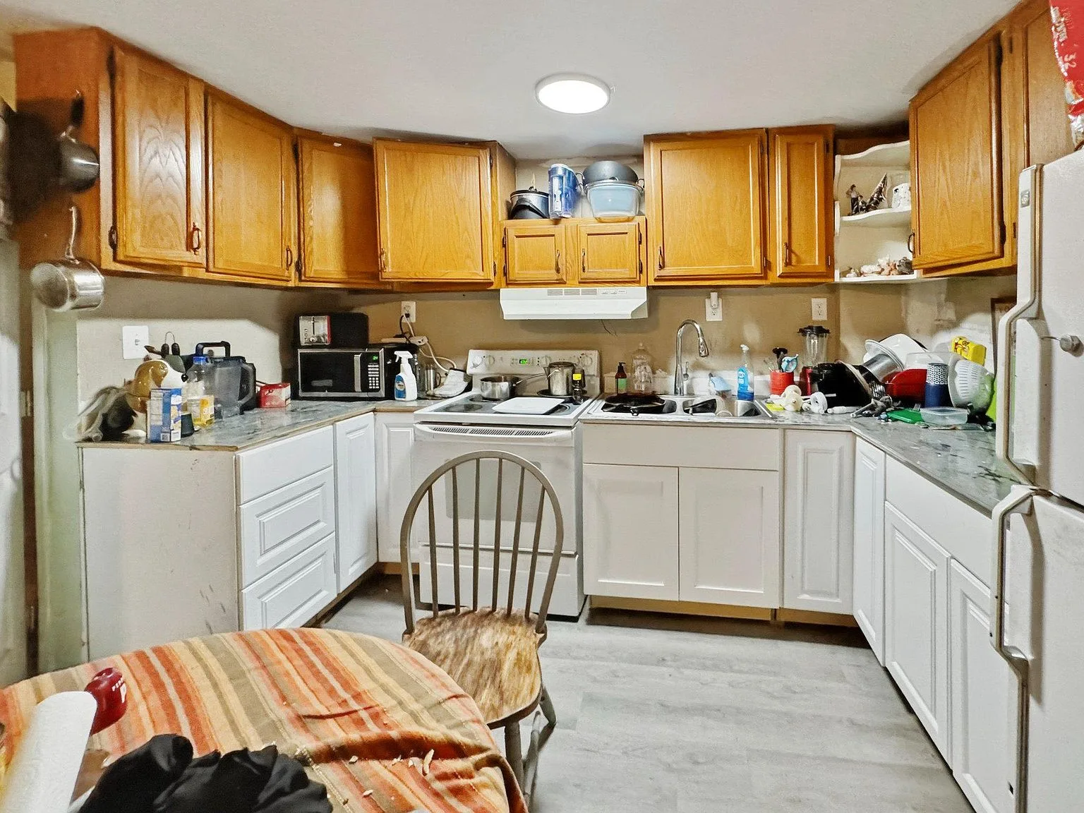 Kitchen with two-tone cabinetry and vinyl flooring