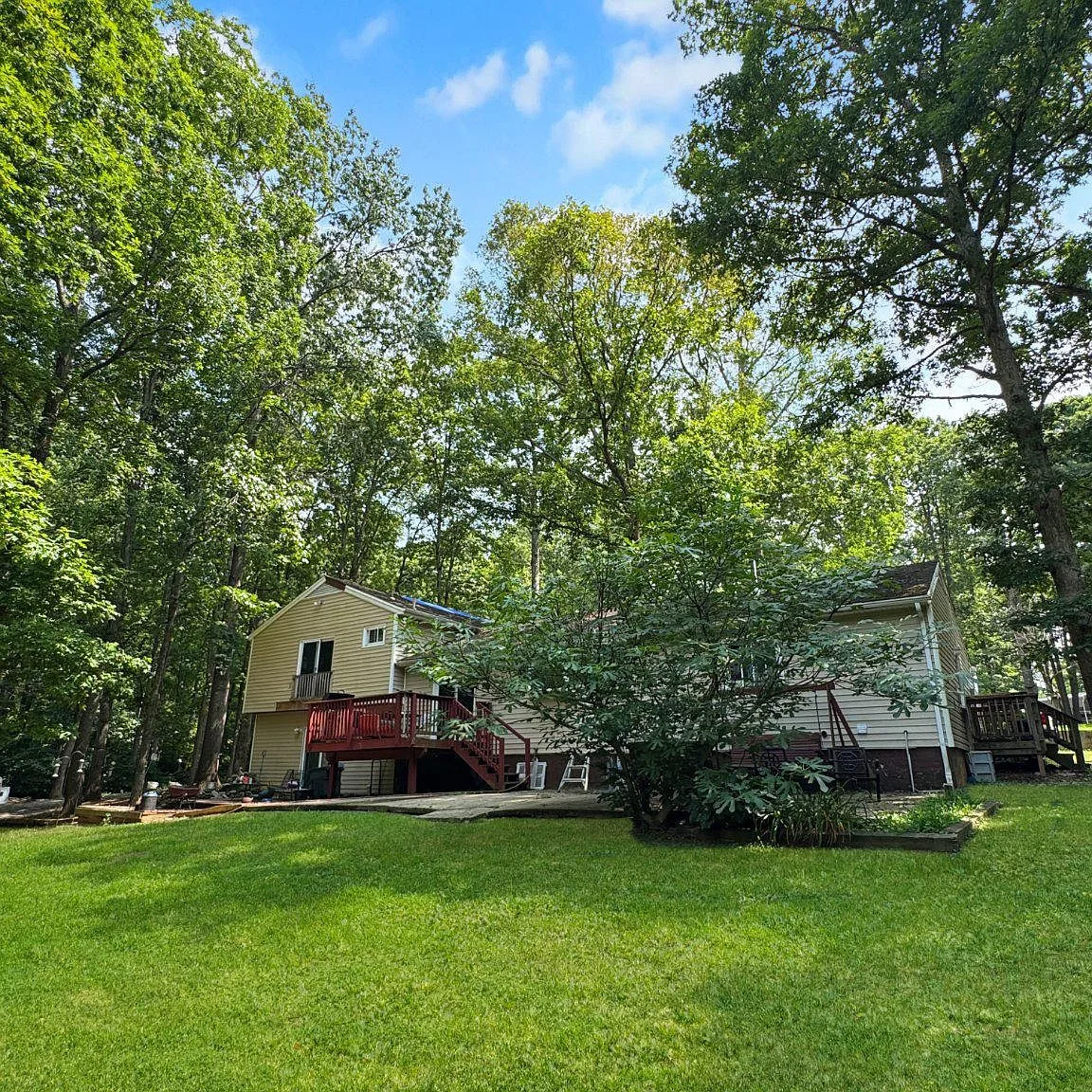 Rear exterior showing wooden deck and lower patio area