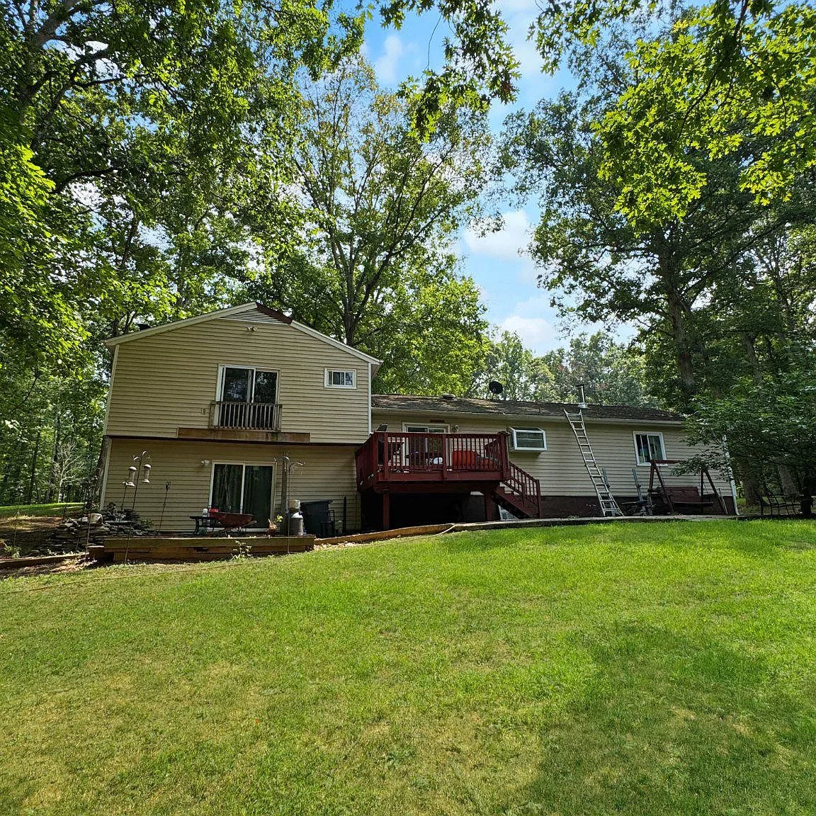 Rear exterior showing large raised deck and stone patio