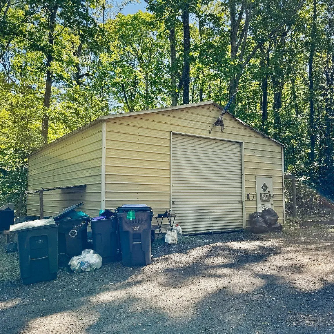Detached metal workshop and garage with roll-up door