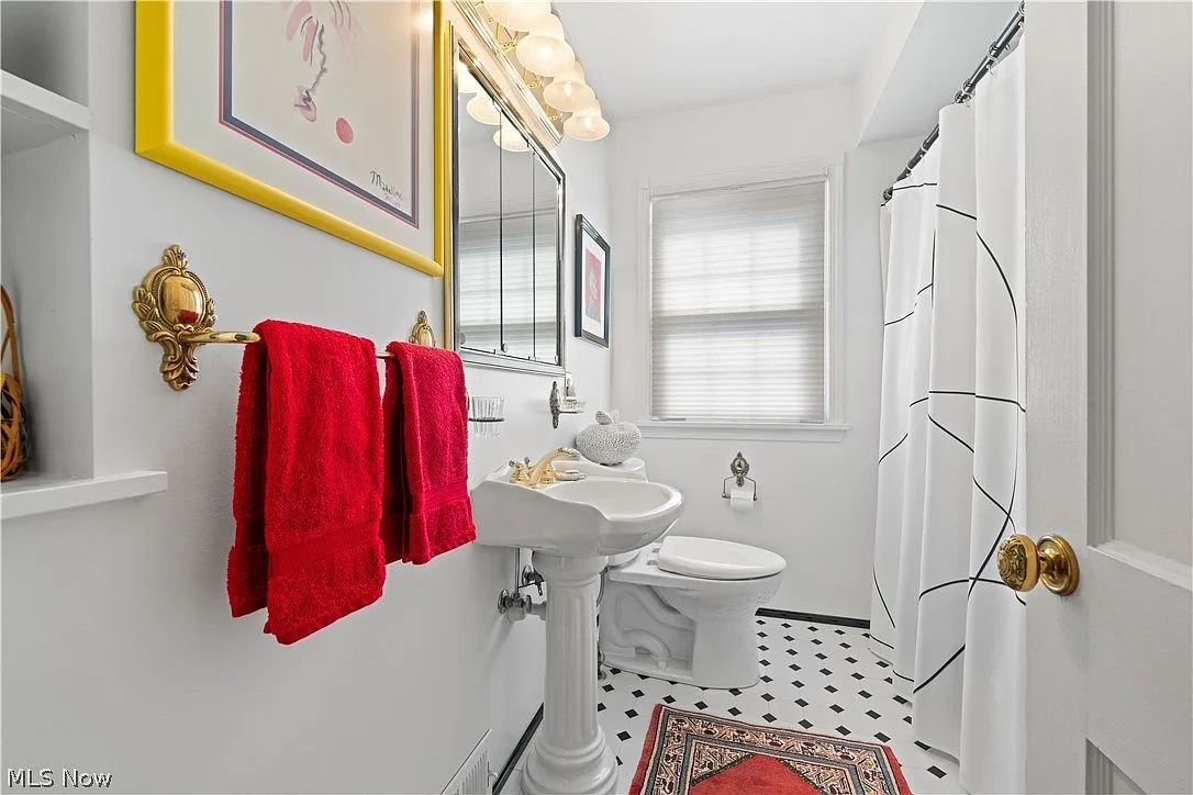Main floor bathroom with black-and-white tile flooring and pedestal sink