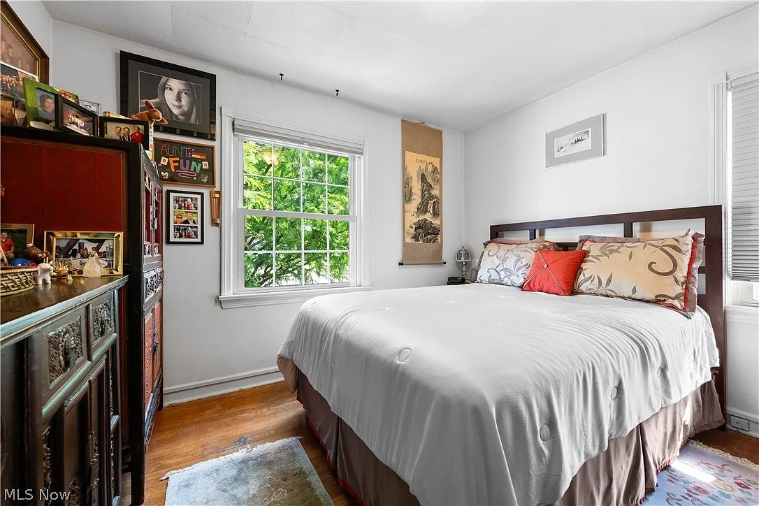 Guest bedroom with hardwood floors and white walls