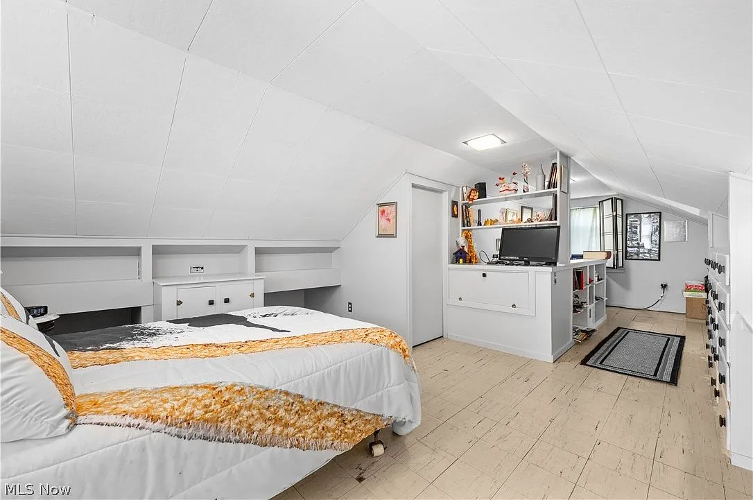 Upstairs bedroom with built-in bookshelves and sloped ceiling