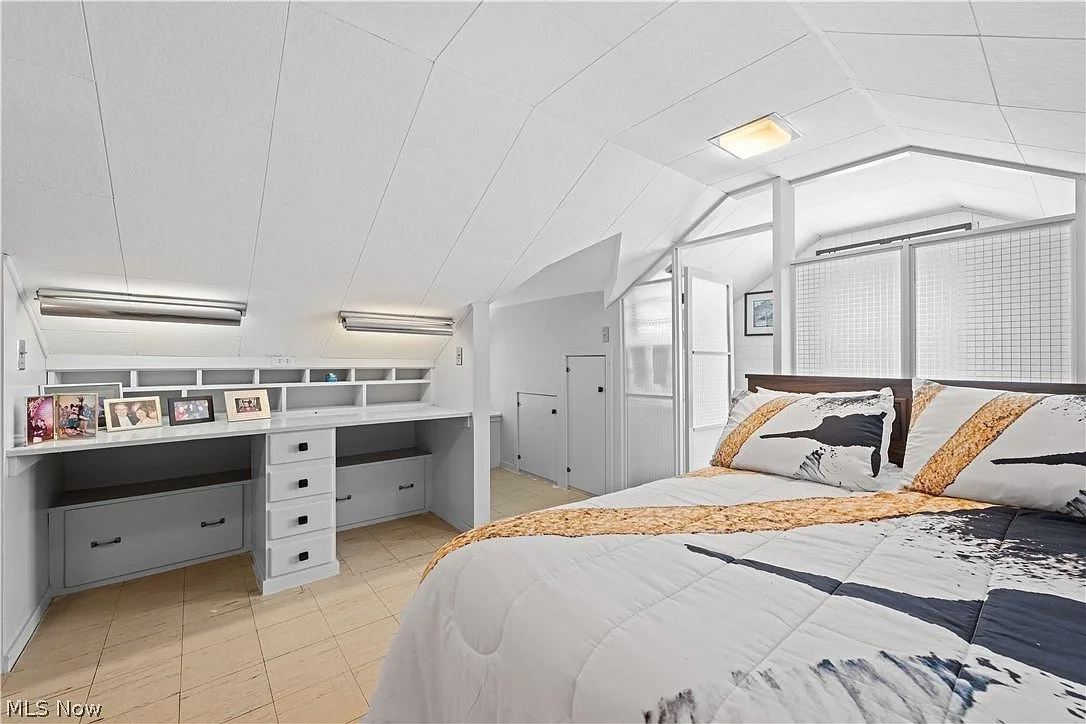 Upstairs bedroom showing built-in desk and cabinetry under angled ceiling