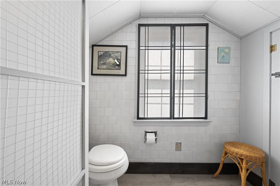 Upstairs half bath with white subway-tiled walls