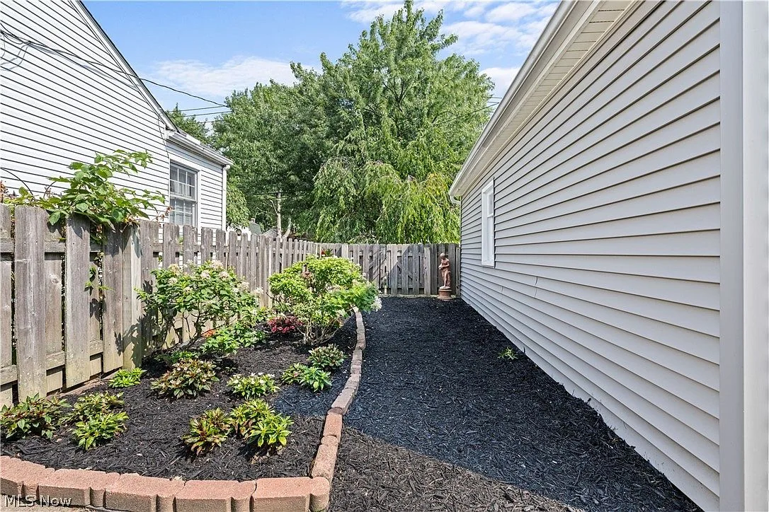 Landscaped side yard with dark mulch and brick edging