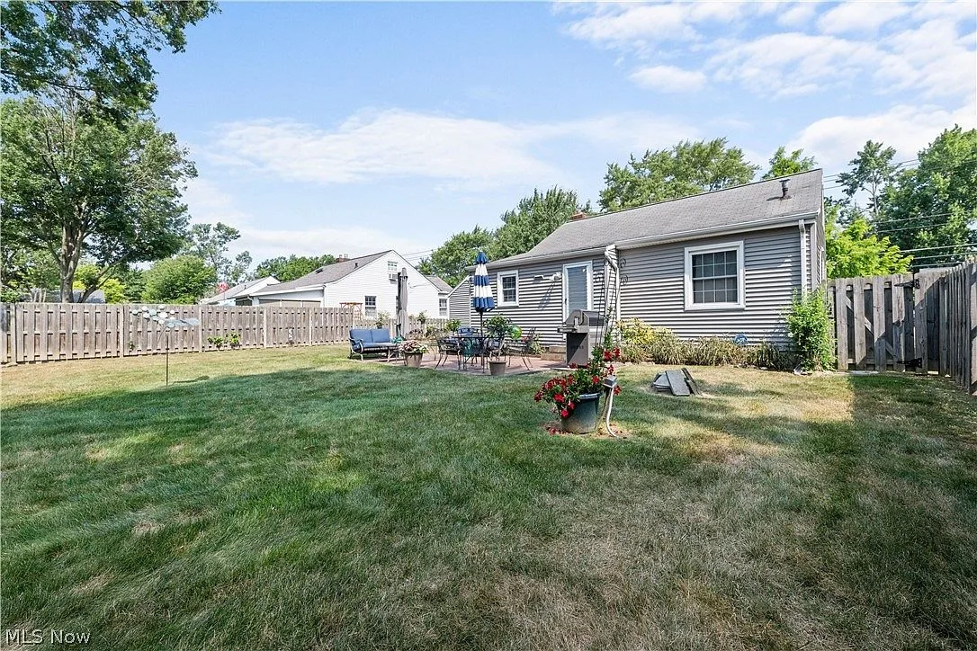 Fully fenced backyard with patio furniture and landscaping