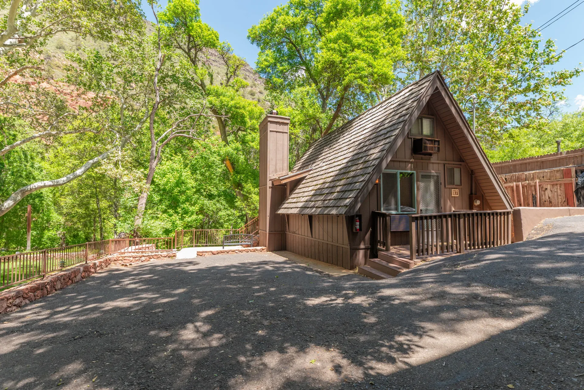 A-frame cabin unit with shake-shingle roof and red rock backdrop
