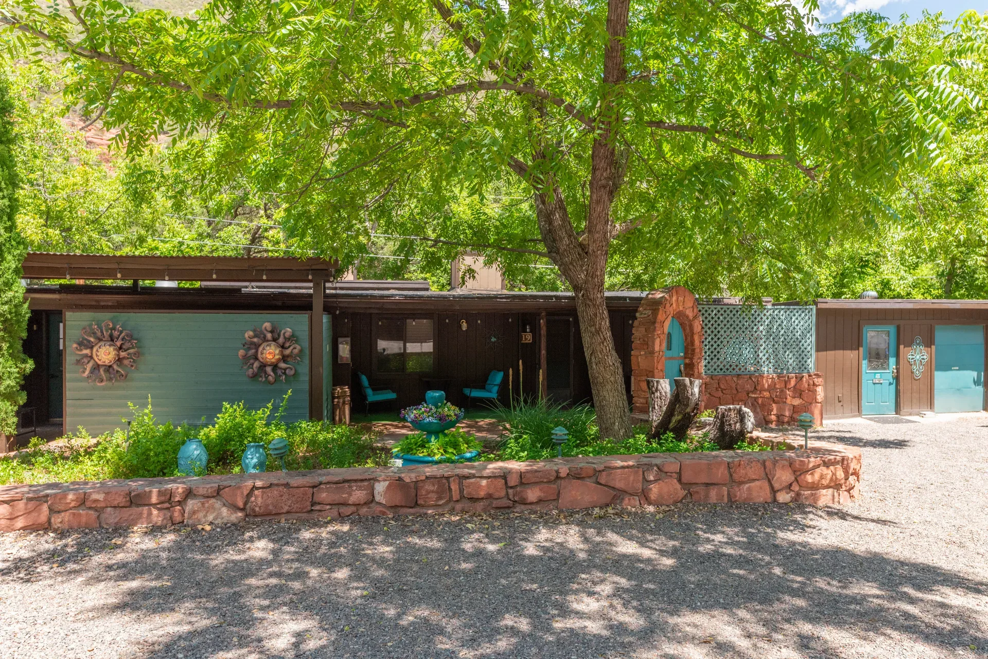 Bungalow facade with brown wood siding and teal accents