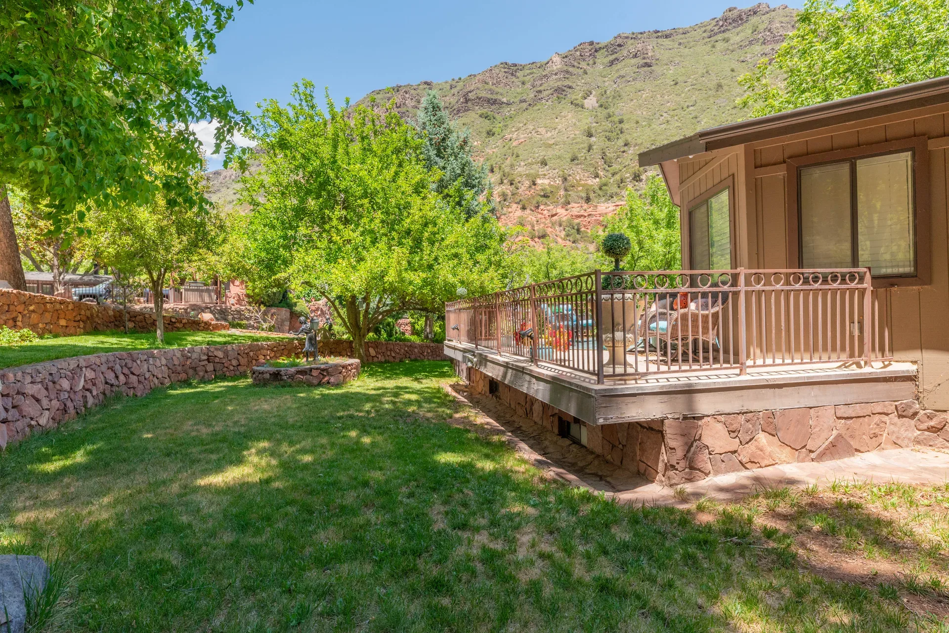 Bungalow backyard with stone retaining walls and lawn