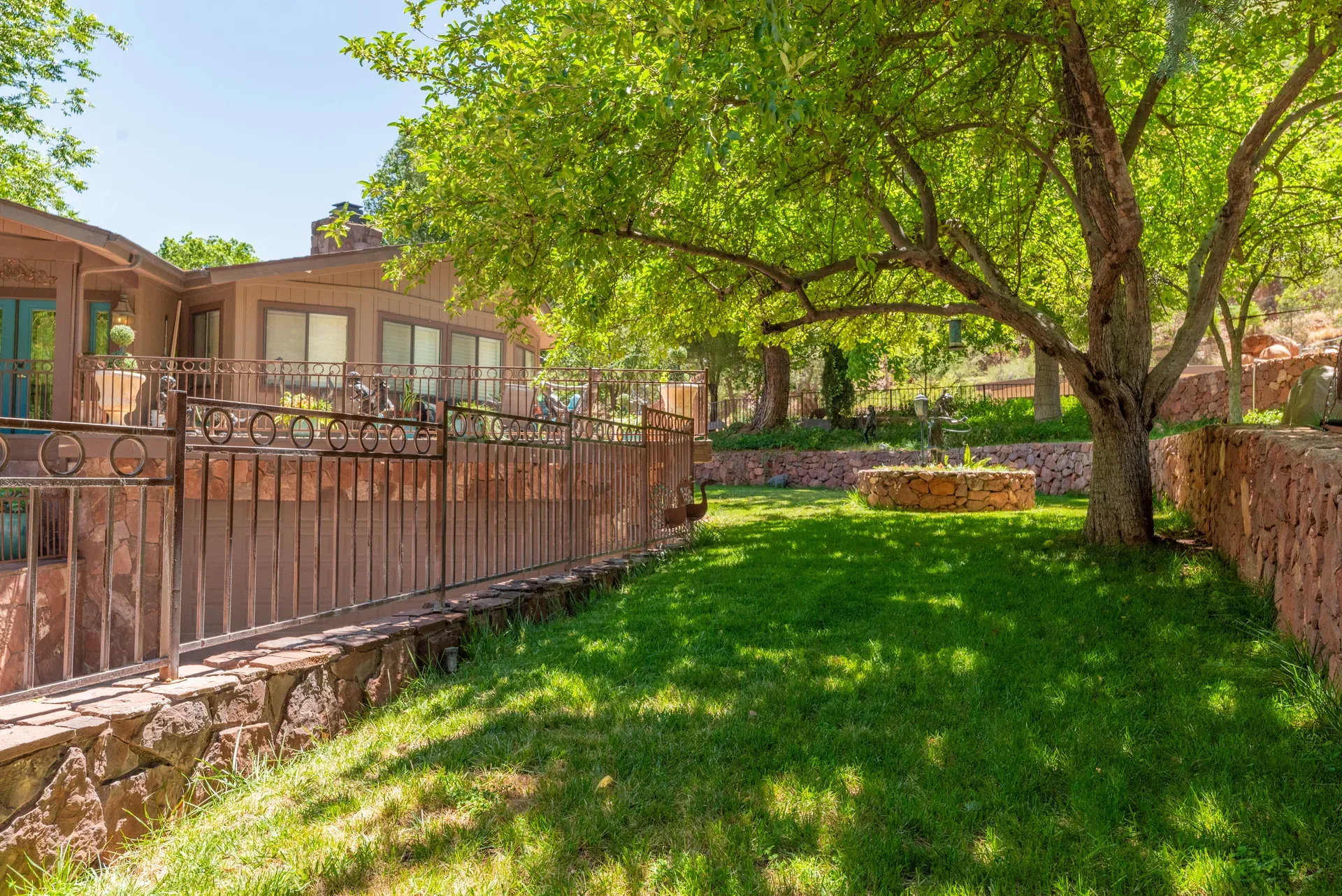 Landscaped backyard with green lawn and stone walls