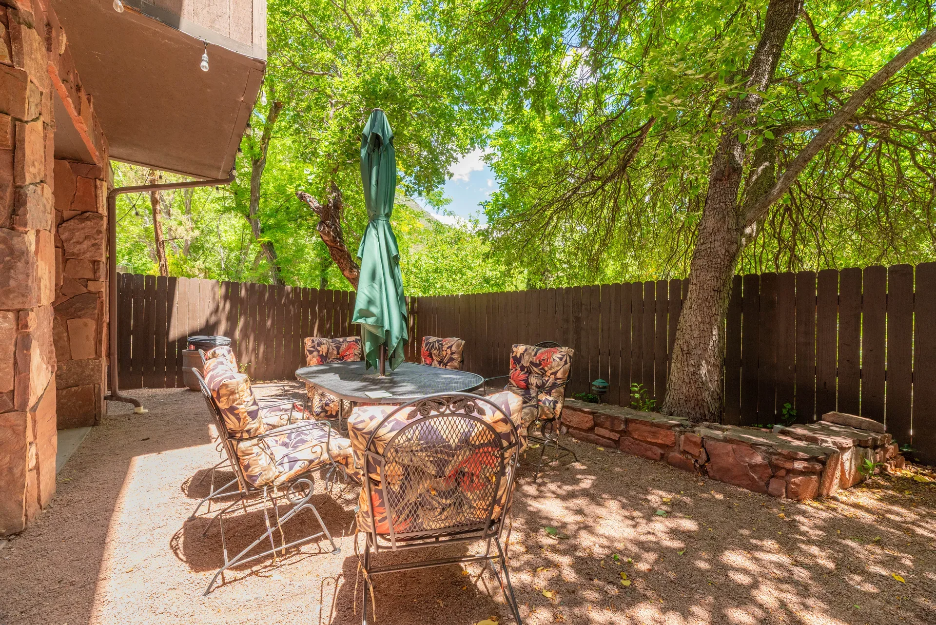 Outdoor patio space with stone architecture and dappled sunlight
